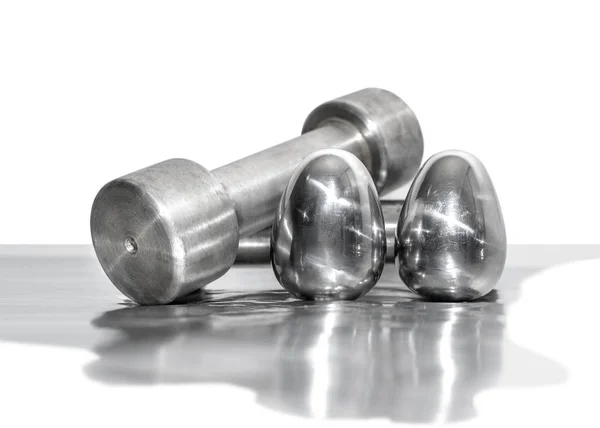 Metal dumbbells and steel eggs, the concept of sports training and the achievement of muscle strength — Stock Photo, Image