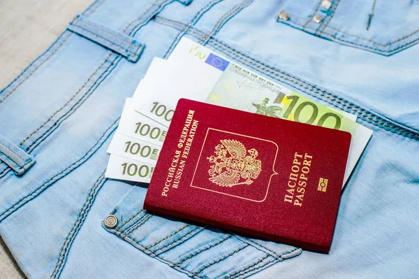 Κόκκινο ρωσικό διαβατήριο με νομοσχέδια τα χρήματα για τζιν. Η έννοια του ταξιδιού. — Φωτογραφία Αρχείου