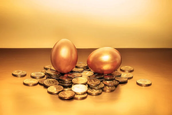 Золотые монеты и золотые яйца, концепция финансового роста — стоковое фото