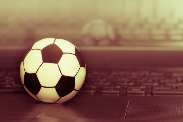 Souvenir voetbal op het toetsenbord van de laptop. Het concept van een voetbalwedstrijd. — Stockfoto