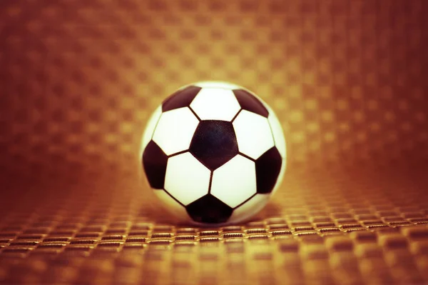 En leksak fotboll på en konstgjord bakgrund. Begreppet fotboll. — Stockfoto