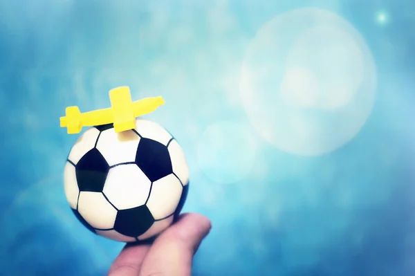 サッカー ボールに黄色のおもちゃの飛行機。サッカー選手権への飛行の概念. — ストック写真