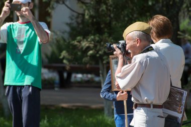 Kursk bölgesi, Zheleznogorsk, Rusya Federasyonu - 9 Mayıs 2018. Bir askeri yeşil şapkalı yaşlı bir adam ölümsüz alayın bir geçit yakınları portreleri ile İkinci Dünya Savaşı, Rusya çizer..