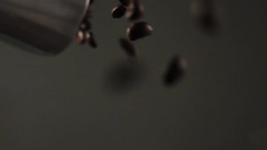 Kameraya bir kepçeden kahve çekirdekleri dökülüyor. Taze kokulu kahve çekirdekleri. Yavaş Hareket.