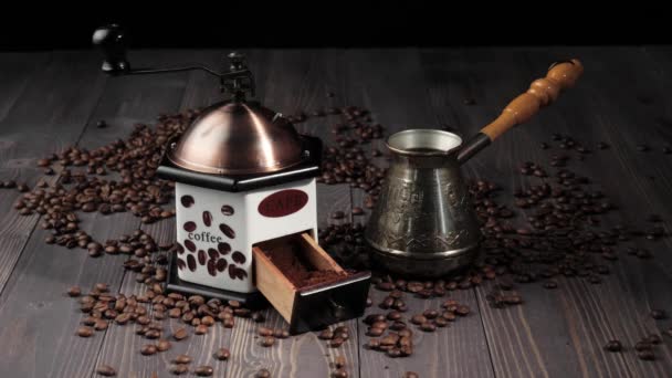 コーヒー豆から構成されます 香り高いコーヒー豆で飾られた木製のテーブルの背景 手は木製のテーブルからコーヒーメーカーを取ります — ストック動画