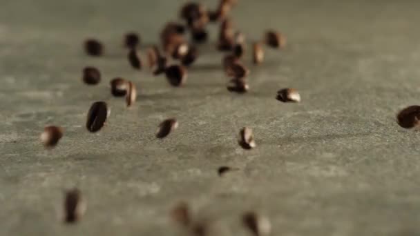 焙煎されたコーヒー豆はセラミックの背景に落ちます フレッシュな落下コーヒー豆の香り スローモーション — ストック動画