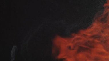 Alttan gelen gerçekçi soyut duman efekti, sol tarafta yağmur ve sağ tarafta uzayda yanan sıcak alevler. Su püskürtücü ve ateş parıltısıyla ağır çekimde duman..