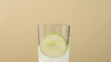 Çay seremonisi. Naneli şeker şeffaf bardağa düşer. Masada parlak arka planda buz küpleri olur. Modern soğuk Çin töreni.