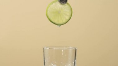 Çay seremonisi. El şeffaf bardağa kireç koyar ve parlak arka planda buz küpleri olur. Modern soğuk Çin töreni.