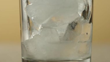 Çay seremonisi. Buzlu çay şeffaf bir bardağa dökülür. Buz küpleri ve parlak arka planda duran limon dilimleri ile. Modern soğuk Çin töreni. Kapat..