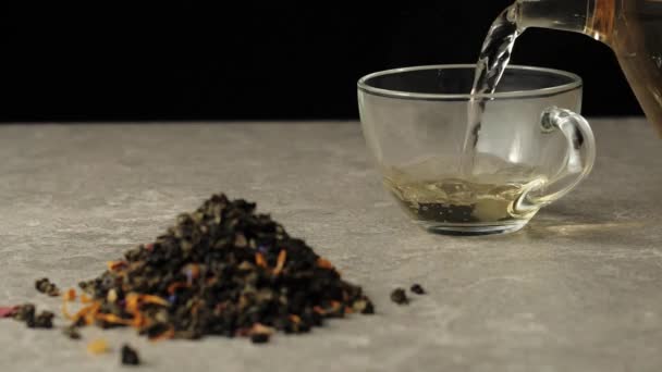 绿茶倒入一个透明的杯子 放在桌上 在绿茶叶堆旁边的黑色背景下 — 图库视频影像