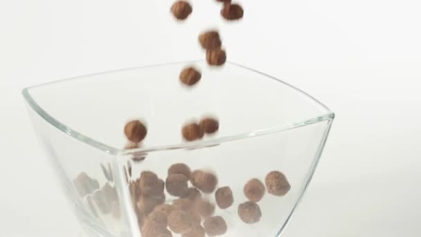 新鮮な健康食品 チョコレートシリアルボールは白い背景の透明な正方形のボウルに落ちる 健康的な朝食 きれいな食事 デトックス ベジタリアン ビーガンフードの概念 トップ表示 — ストック動画