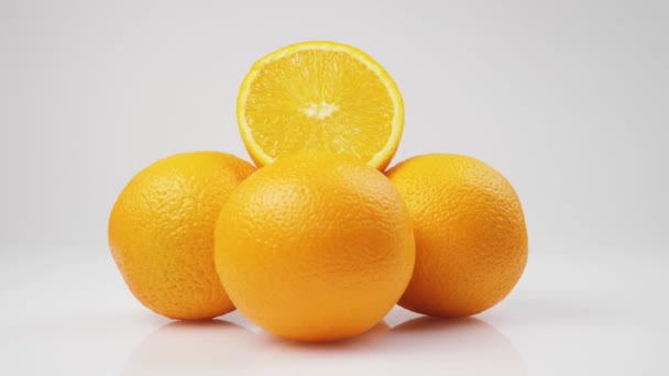 白い背景に白いテーブルの上にオレンジの束の真ん中のショットは 孤立して回転します — ストック動画
