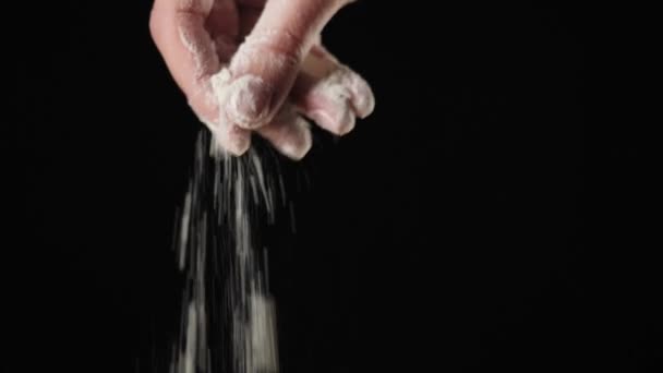 Профессиональный Пекарь Руки Посыпать Муку Черном Фоне Падающие Белые Частицы — стоковое видео