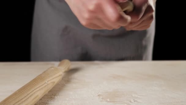 专业烘培师的手把面团伸向空中 为一个黑色背景的披萨基地做准备 面团揉搓和烹调美味披萨的概念 靠近点4K — 图库视频影像