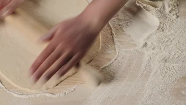 プロのパン職人の手は 小麦粉と木製のテーブルの上に圧延ピンで生地をロールアウト 生地の混練とおいしいピザを調理の概念 最上階だ — ストック動画