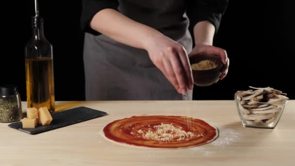 Profi Koch Gießt Geriebenen Käse Auf Einen Pizzaboden Mit Tomatenmark — Stockvideo