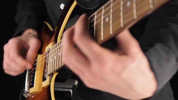 Gitarrist Spielt Eine Hellbraune Sechssaitige Gitarre Mit Pickel Vor Schwarzem — Stockvideo