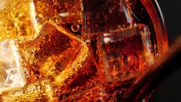 Ледяные Кубики Плавают Вращаются Пузырьками Стакане Колы Коричневыми Подсветками Черном — стоковое видео