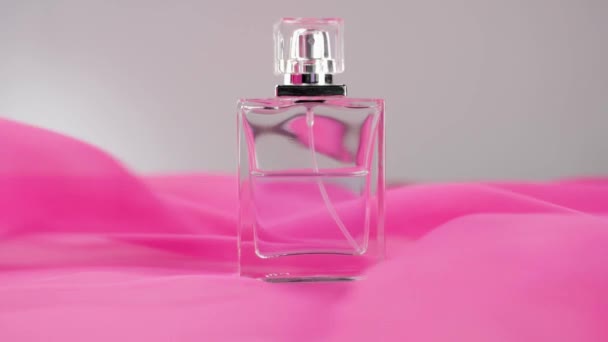 Vlakke Parfumfles Met Cyaanparfum Etherische Oliën Witte Tafel Roze Stof — Stockvideo