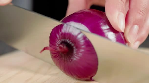 女人用锋利闪亮的小刀在木板上切下新鲜的紫色洋葱 用生菜 樱桃西红柿 黄瓜和洋葱做夏季新鲜沙拉的概念 靠近点4K — 图库视频影像