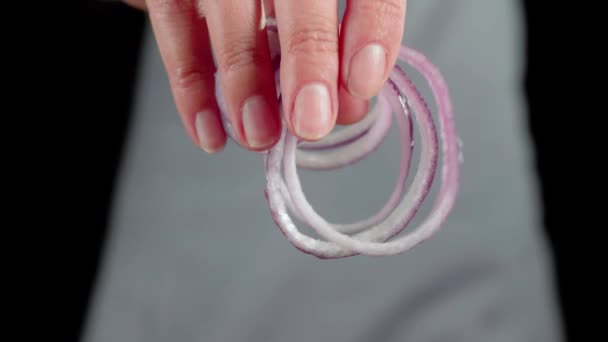 Salade d'été. Chef professionnel verse l'oignon violet tranché dans un bol en verre. Concept de faire de la salade d'été fraîche à partir de laitue, tomates cerises, concombres et oignons. Ferme là. 4K 