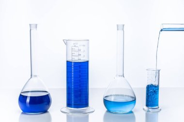 Mavi sıvıyla test tüpü ve matara. Kimya ve laboratuvar c