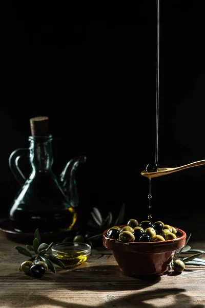 橄榄油和木桌上的橄榄枝 — 图库照片