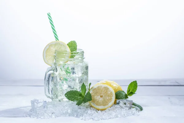 Pitcher of very refreshing lemonade with lemons, mint and ice, on white background — Stock Photo, Image