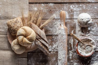 Tahtada buğday kulaklı ekmek ve un, üst manzara. 