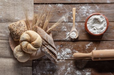 Tahtada buğday kulaklı ekmek ve un, üst manzara. 