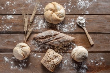 Tahtada buğday kulaklı ekmek ve un, üst manzara. 