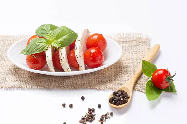 Mozzareela, tomaat en basilicum, op witte achtergrond. Mediterrane voeding en gezond voedsel concept. — Stockfoto