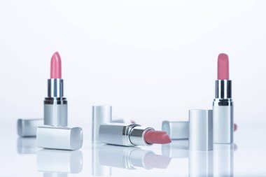 Beyaz arka planda kırmızı ve gümüş ruj, güzellik ve moda konsepti.