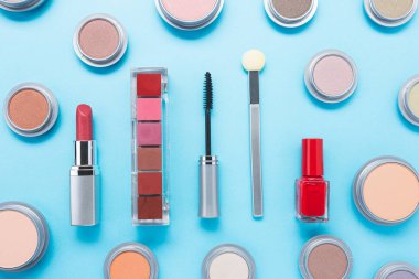 Mavi arka planda farklı makyaj ürünleri olan kompozisyon, üst manzara. güzellik ürünleri ve moda konsepti.