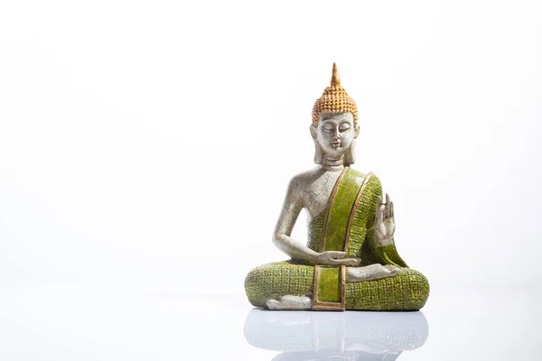 Зелёная и золотая статуя Будды, на белом фоне. Медитация, духовность и дзен-концепция . — стоковое фото