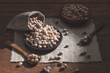 Tahta bir tabağa dökülmüş nohut, ahşap bir tabağa dökülmüş tahta kaşıklar.. 