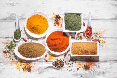 Beyaz ahşap arka planda çeşitli baharatlar. Kopyalama alanı olan üst görünüm. Yemek malzemeleri ve baharat konsepti.