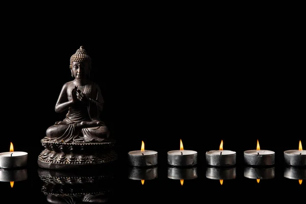 佛像静坐着 烛光线与黑色复制空间 禅与冥想的概念 — 图库照片