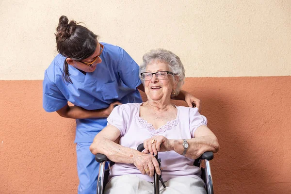 Mujer Mayor Feliz Con Bastón Silla Ruedascon Cuidador Casa Están — Foto de Stock