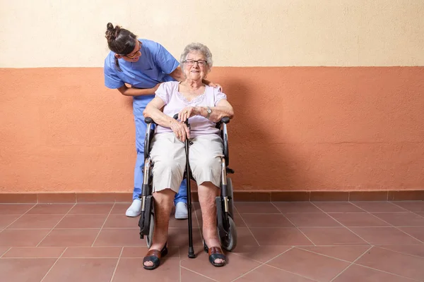 Mujer Mayor Feliz Con Bastón Silla Ruedascon Cuidador Casa Están — Foto de Stock