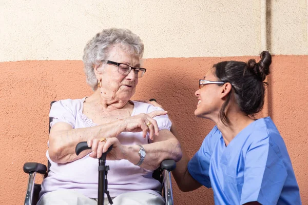 Mujer Mayor Feliz Con Bastón Silla Ruedascon Cuidador Casa Están — Foto de Stock