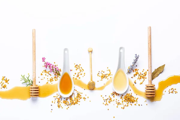 Weiße Löffel Und Honigstangen Mit Verschüttetem Honig Bienenpollen Und Blüten — Stockfoto