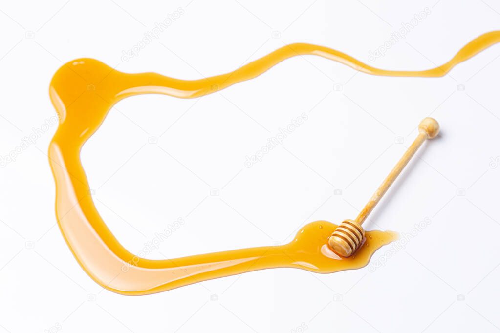 Honey stick, with spilled honey isolated on white background.