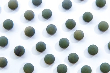 Beyaz arka planda izole klorella hapları.