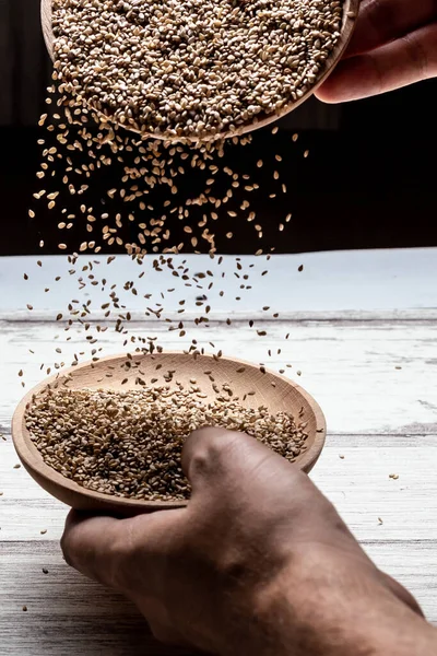 Hands Throwing Sesame Seeds Wooden Plate — Stock Photo, Image