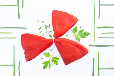 Beyaz arka planda kavrulmuş piquillo biberi, maydanoz ve soğanlı kompozisyon. Üst görünüm.