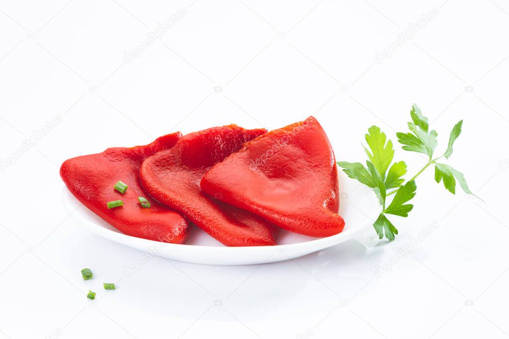 Roasted piquillo peppers on white plate with parsley isolated on  white background.