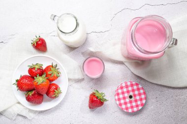 Çilekli Milkshake Sürahisi, beyaz arka planda çilek ve süt. Üst görünüm.
