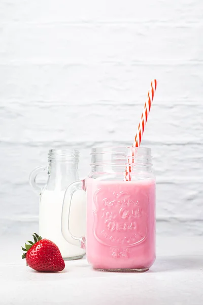 ストロベリーミルクシェークピッチャー イチゴと白の背景にミルク — ストック写真